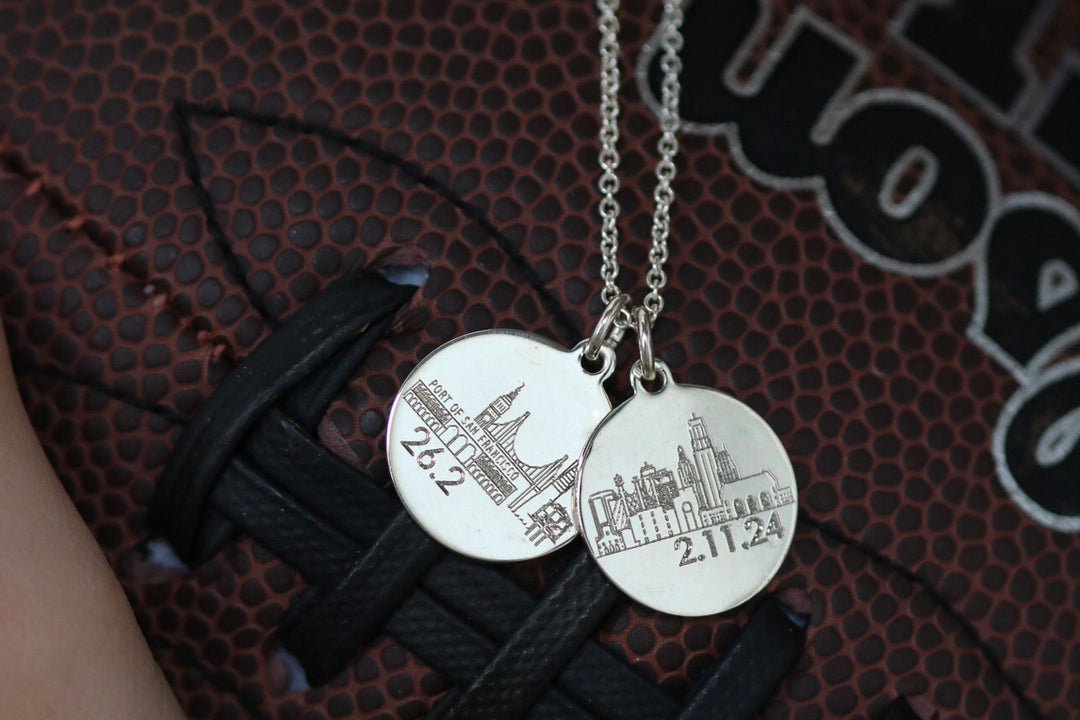 necklaces engraved with city skylines in front of a football